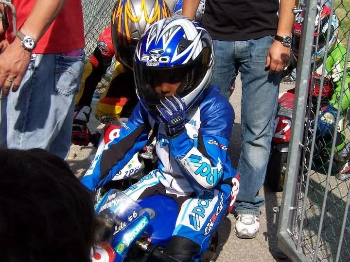 Emanuele da bambino, con casco e tuta, in sella alla sua minimoto