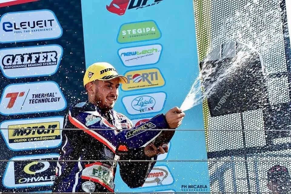Emanuele festeggia sul podio del National Trophy con la tuta J. Angel